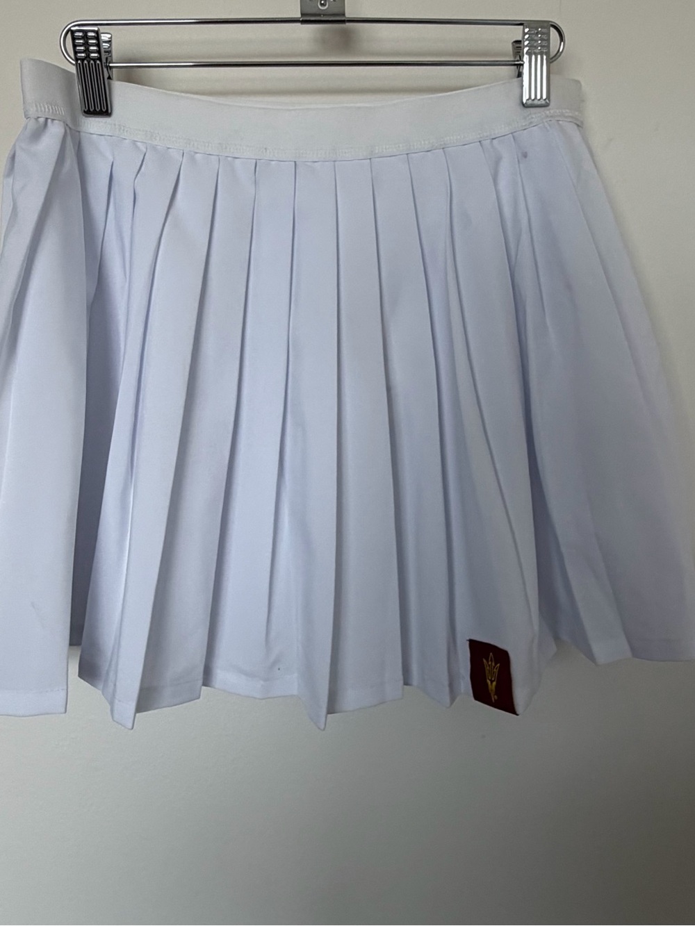 White Pleated Mini Skirt with Subtle Hem Emblem